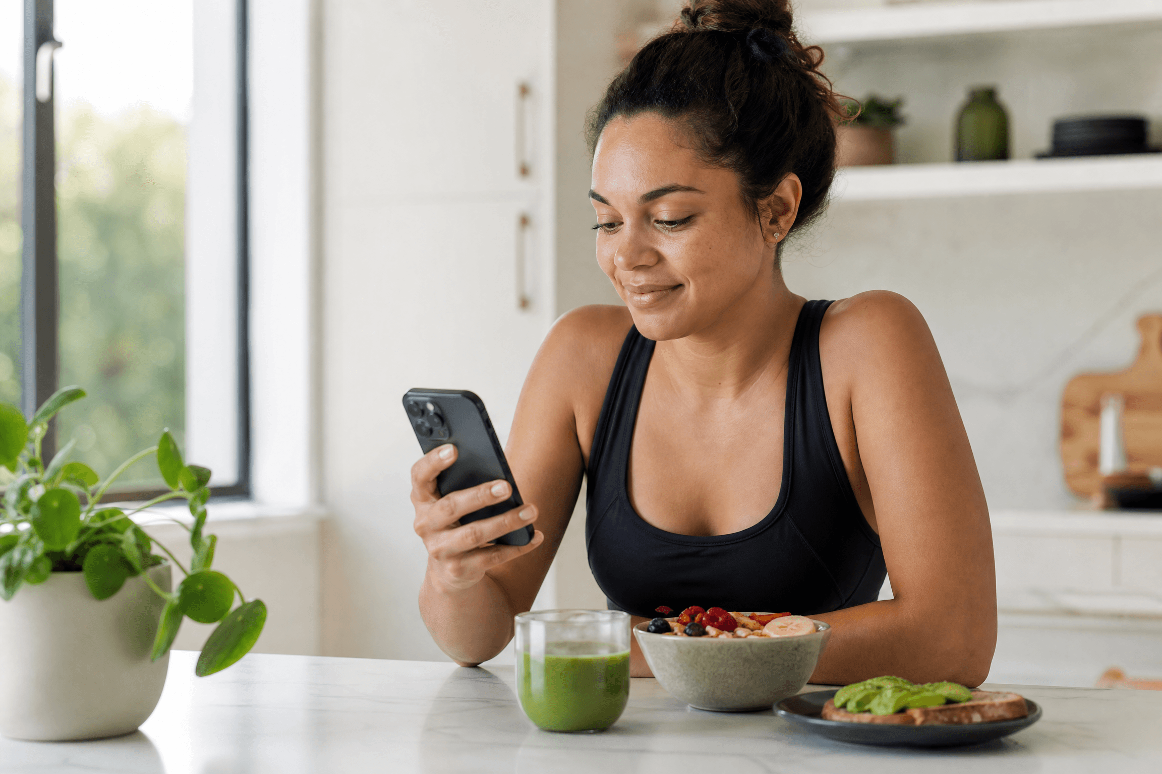 Woman tracking nutrition on phone with healthy food